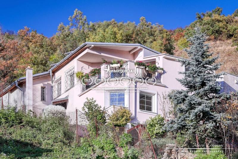A family house in Bratislava - Devín with a balcony, floral decorations, and a lush garden.