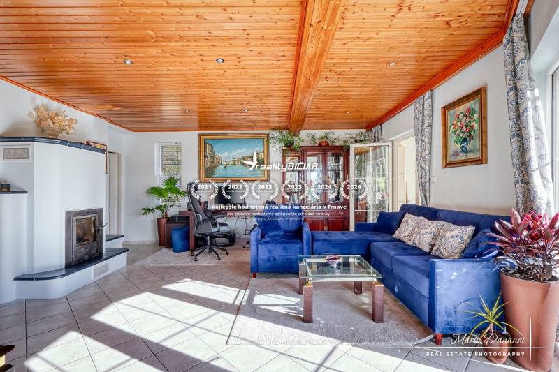 Living room in a family house with a fireplace, blue sofa, and wooden decor flooring.