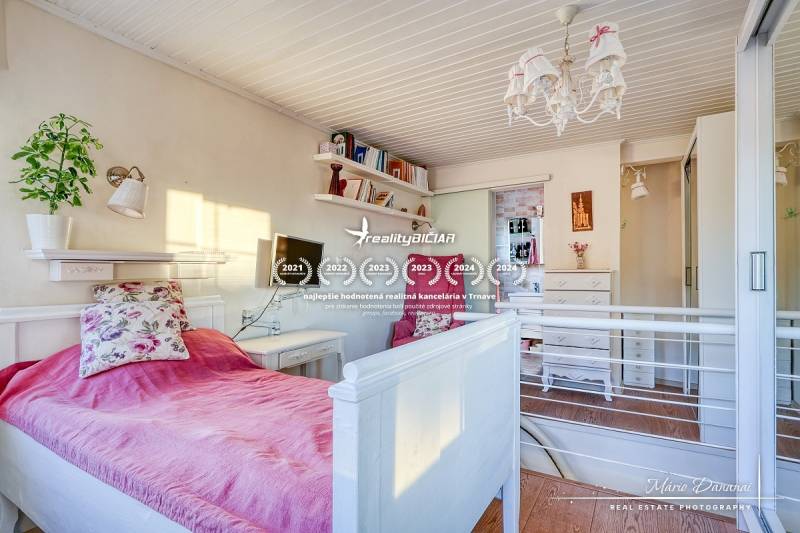 Bright cabin room with a bed, floral pillow, and decorative lighting.