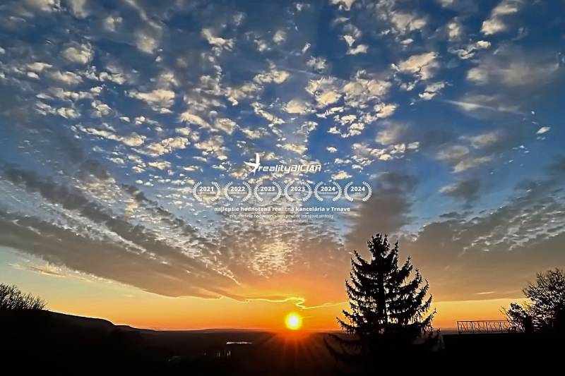 Sunset over the forest and hills in Bratislava - Devín, with clouds in the sky.