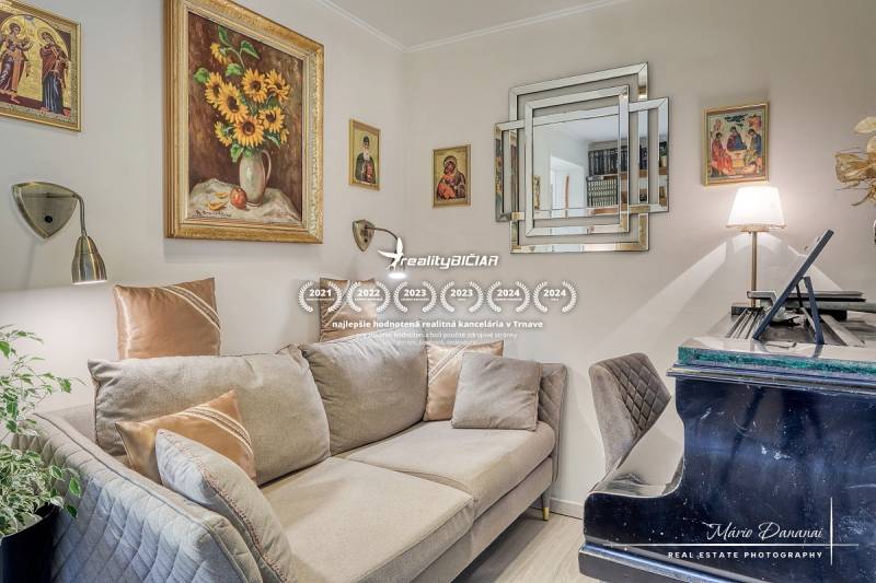 Living room with a sofa, piano, and paintings in a family house.