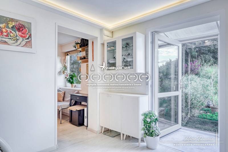 Open doors, shelves, houseplants, and an art painting in the Cottage.