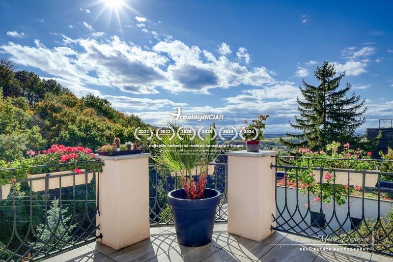 Sunny terrace of the cottage with flowers and a view of the forests in Bratislava-Devínska Nová Ves.