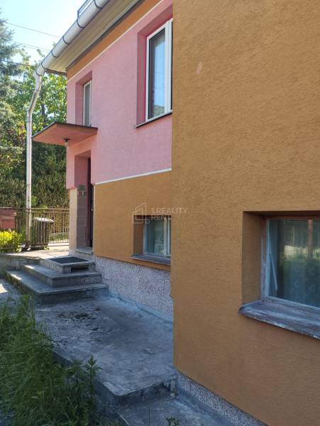 A family house in Divinka on Lalinok Street with a colorful facade and concrete stairs.
