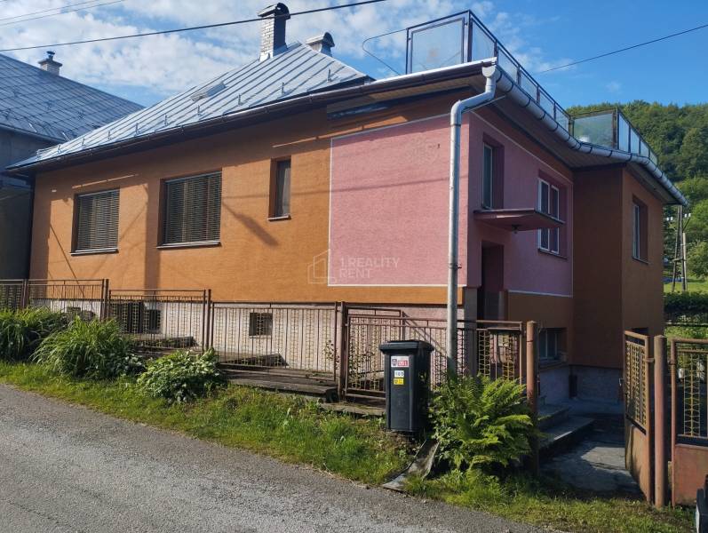 A family house in Lalinok in Divinka, with a colorful facade and a metal fence.