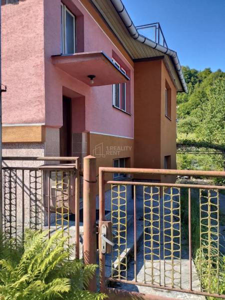 A family house in Divinka on Lalinok Street with a pink facade and a metal gate.
