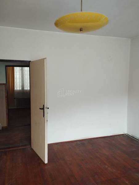A room in a family house with a wooden decor floor and a yellow light fixture.