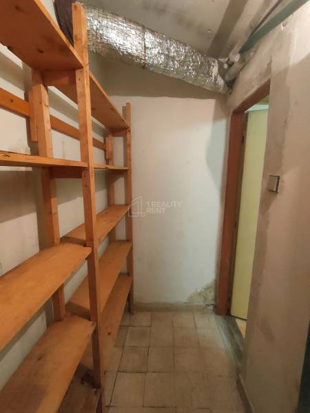 Storage space in a family house with wooden shelves and a light floor.