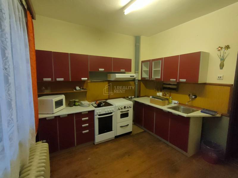 A kitchen in a family house with appliances and a wooden decor floor.