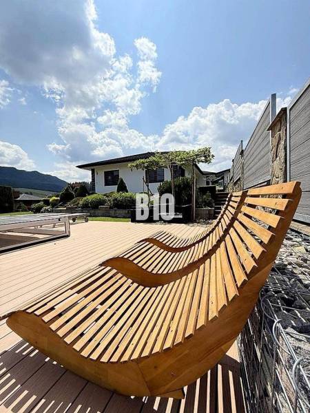 Wooden loungers on the terrace by the villa in Súľov-Hradná, overlooking the garden.