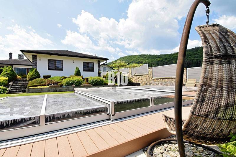 Villa in Súľov-Hradná, landscaped garden with a pool and comfortable outdoor seating.