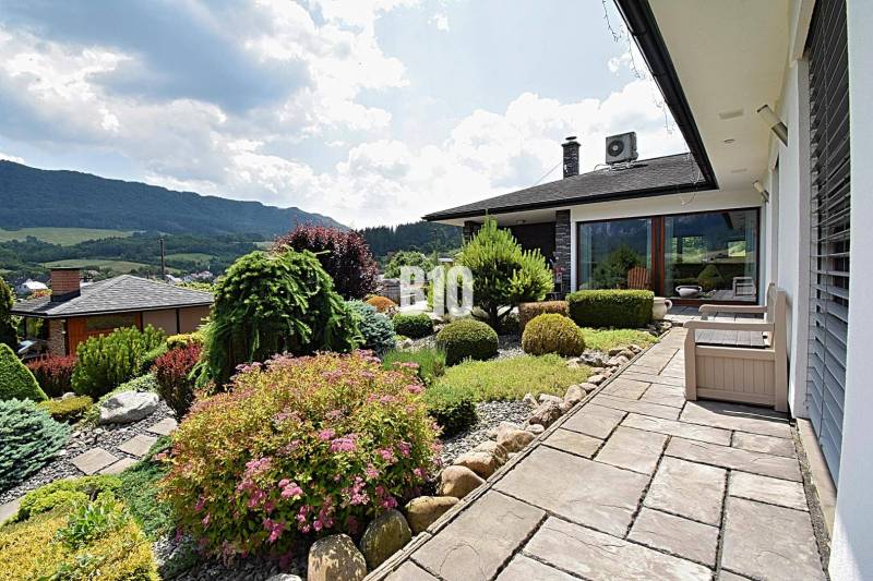 A garden by the villa in Súľov-Hradná with manicured plants and a view of the mountains.