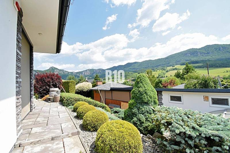 A beautiful garden at the villa in Súľov-Hradná with a view of the mountains and well-maintained vegetation.