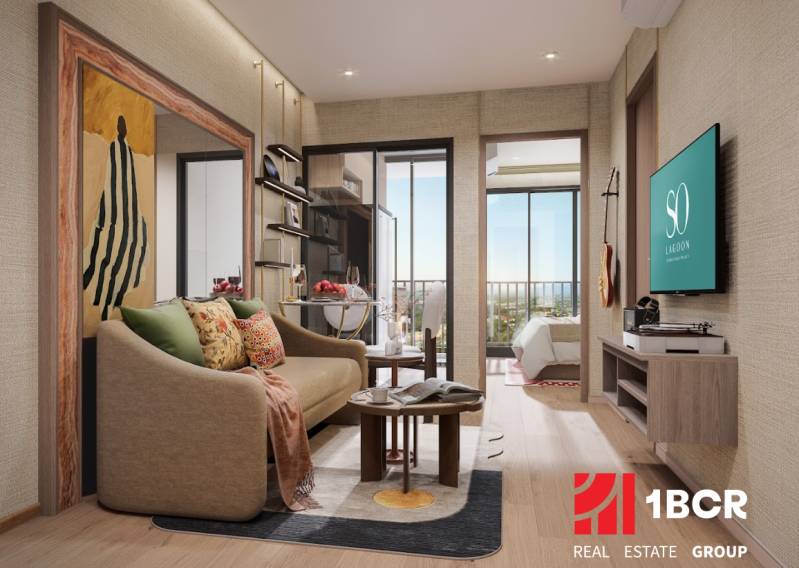 Interior of a 2-room apartment with a wood-patterned floor, a comfortable sofa, and a balcony.