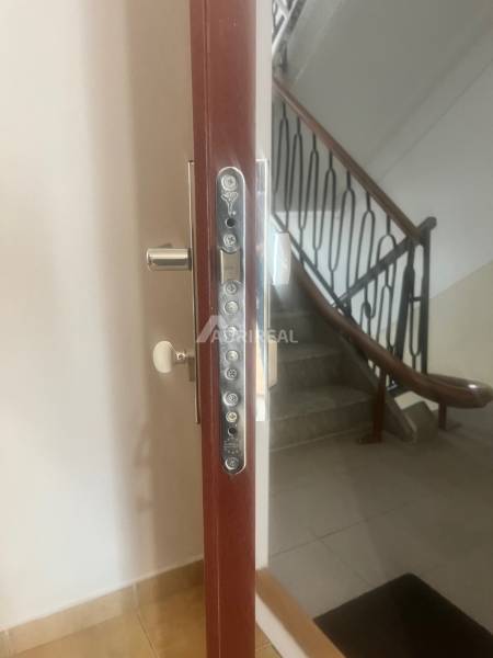 Security entrance door to a 3-room apartment, staircase with a handrail in the background.