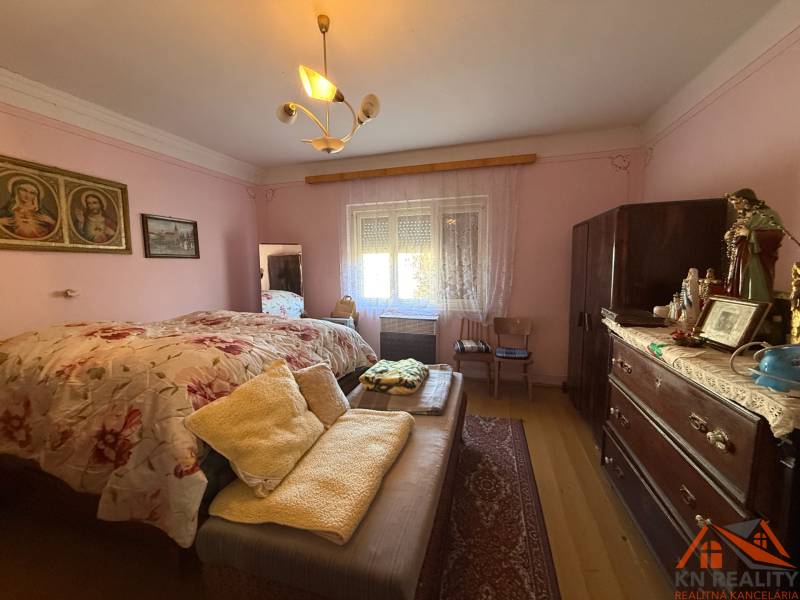 A bedroom in a family house with a wooden decor floor and vintage furniture.