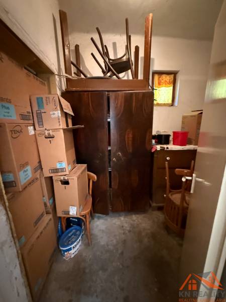 A storage room in a family house with cardboard boxes, old furniture, and closed doors.