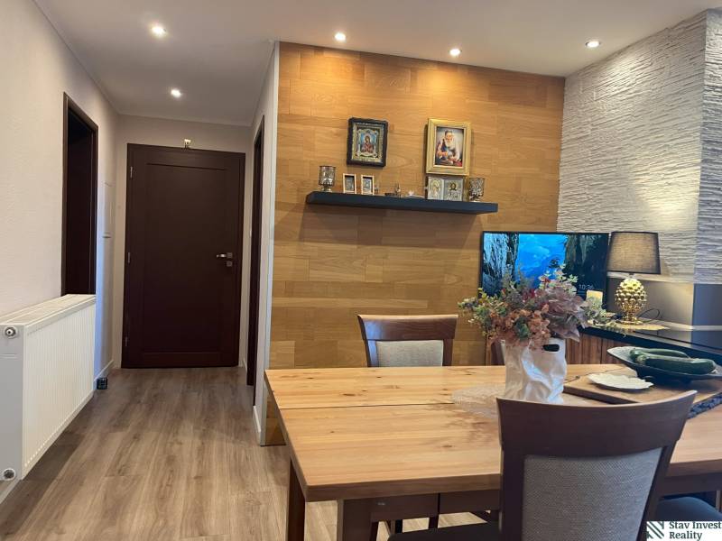 Dining area with a wooden table and decorations in a 2-room apartment.