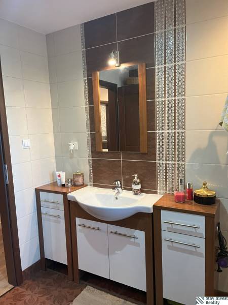 Bathroom sink with mirror in a 2-room apartment, ceramic tiles with ornaments.