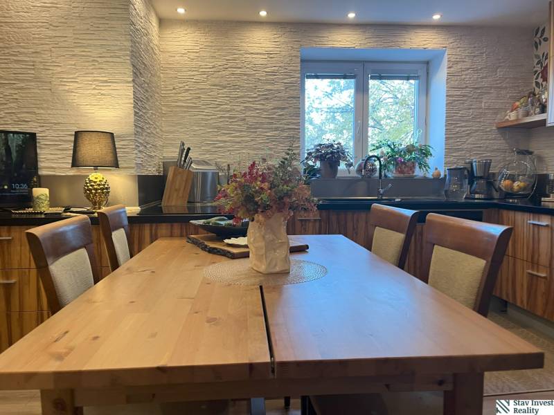 A kitchen with wooden furniture and flowers in a 2-room apartment.