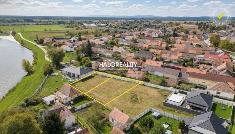 Aerial view of residential land in the village of Brodské near the river.