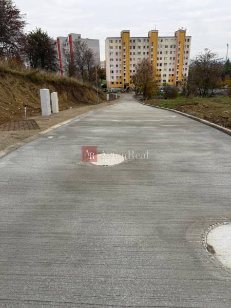 A new road in Liptovský Mikuláš, Podbreziny Háje, leads to apartment buildings. Land - residential.