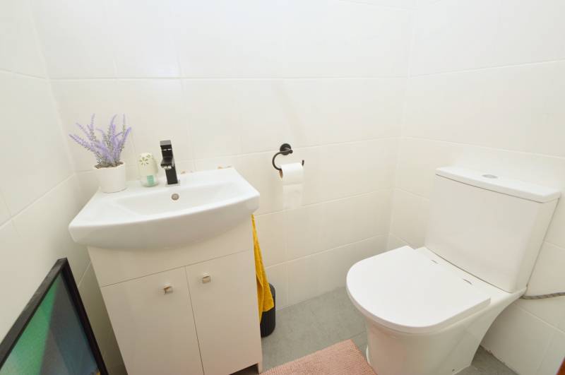 Bathroom in a 3-room apartment with white tiles and a stylish sink.