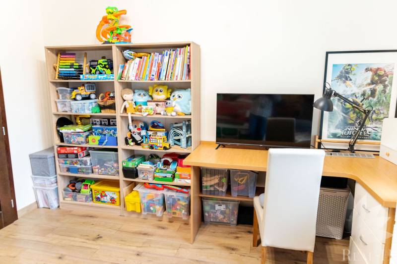 A children's room with shelves full of toys and a table in a 3-room apartment.