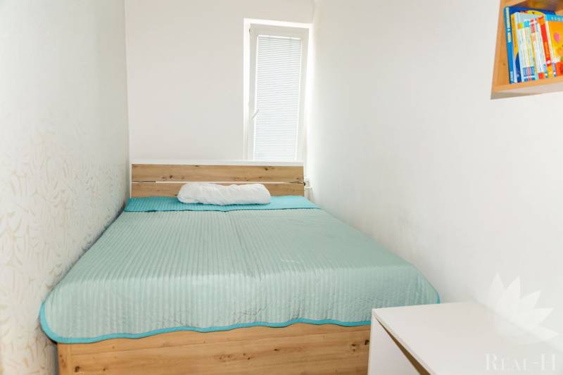 Bedroom in a 3-room apartment with a bed and a white dresser.