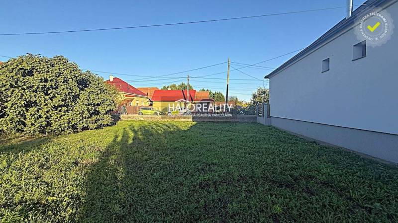 Plots - housing in Kameničná with grassy vegetation and surrounding development.