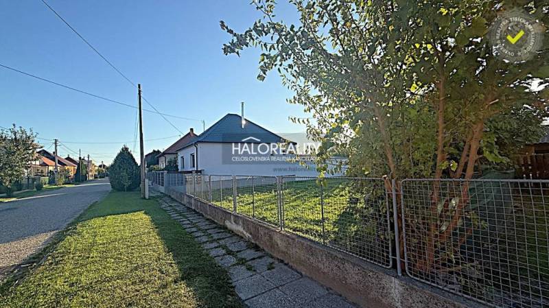 A peaceful street in Kameničná with family houses and green plots for living.
