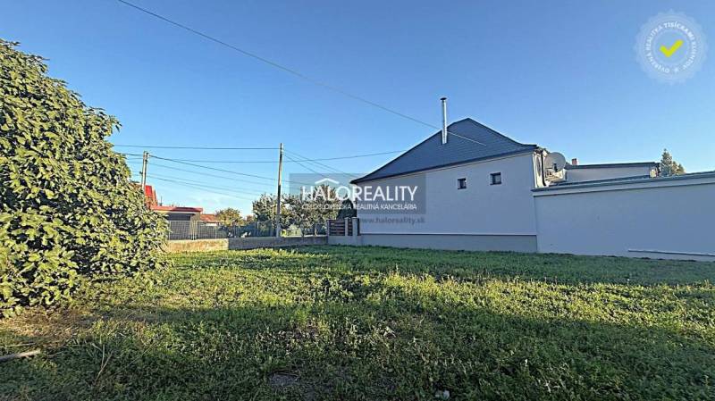 Plots in Kameničná with grassy area and a white house, ideal for living.