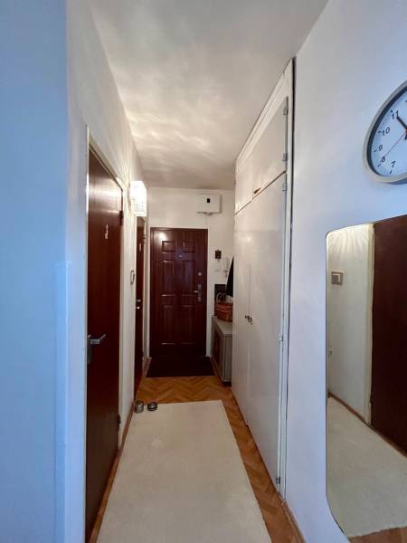 A narrow entrance area with a wooden decor floor in a 2-room apartment.