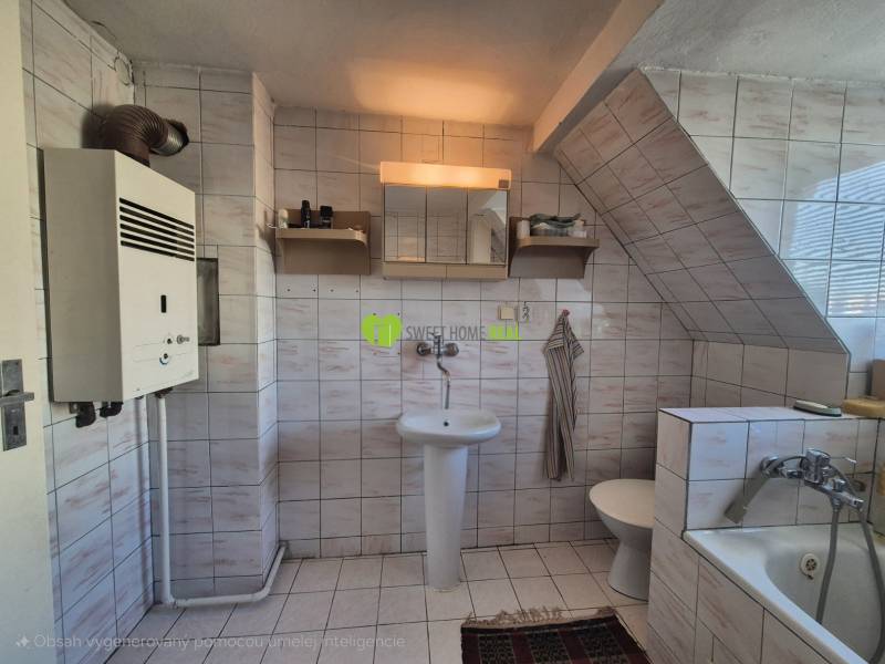 A bathroom in a family house with a bathtub, a sink, a gas boiler, and white tiles.