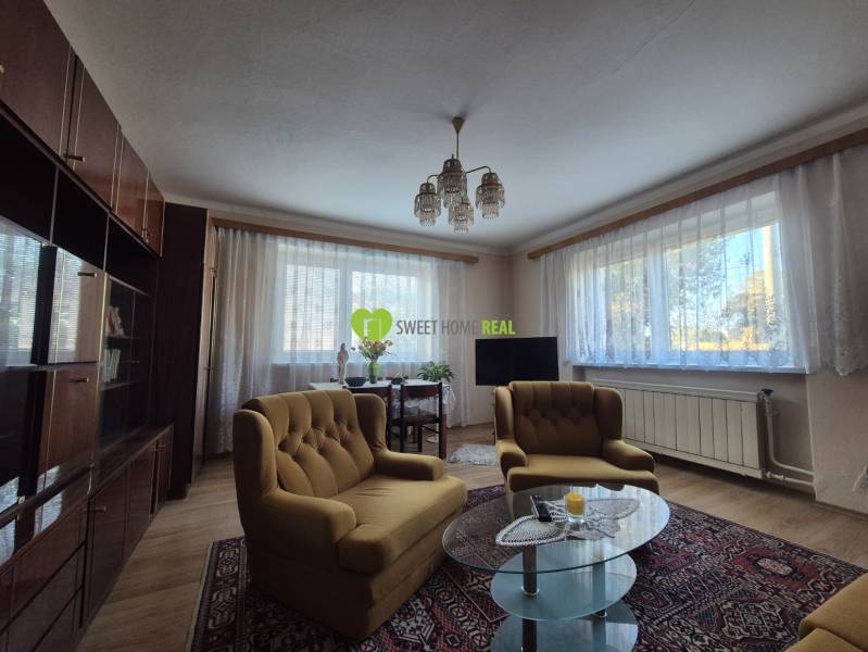Living room in a family house with comfortable seating, floor with wooden decor.