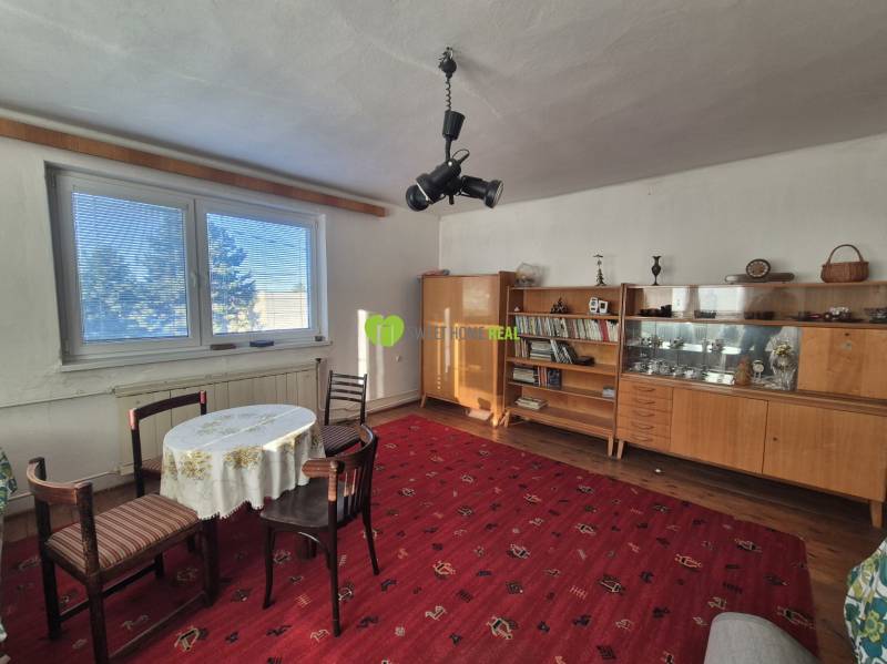 Living room with furniture and a table on a red carpet in a family house.