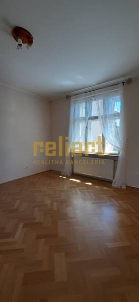 A room in a 4-room apartment with a wooden decor floor and a large window.