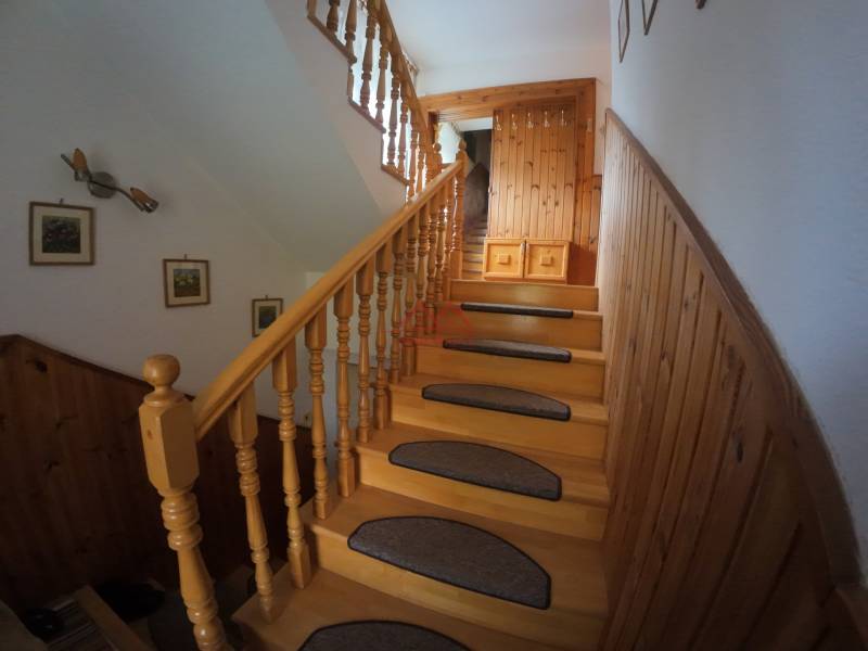 A staircase in a family house with wooden decor and decorations on the walls.