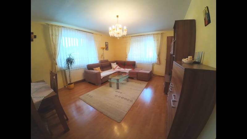 Living room in a family house with a wooden decor floor and a corner sofa.