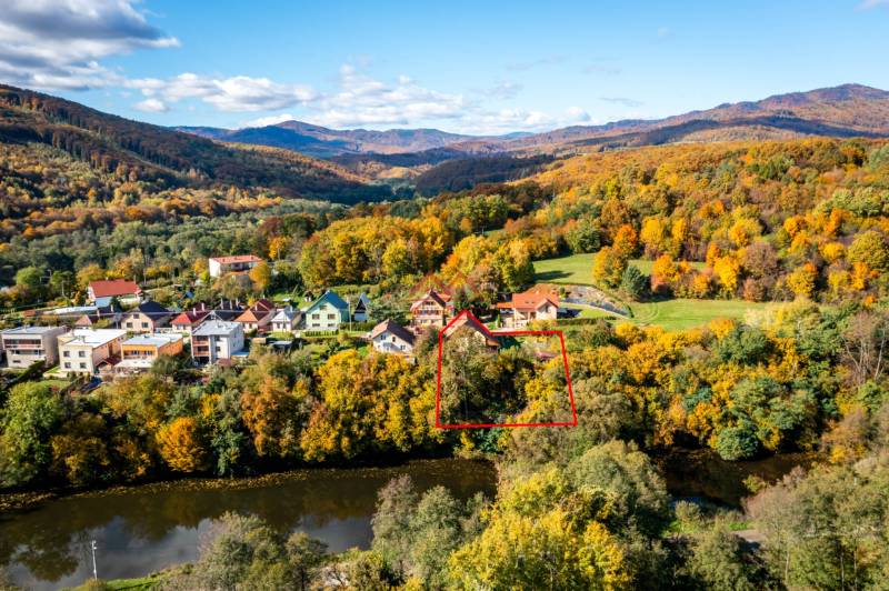 A family house in Medzev surrounded by autumn nature, with a view of the river and mountains.