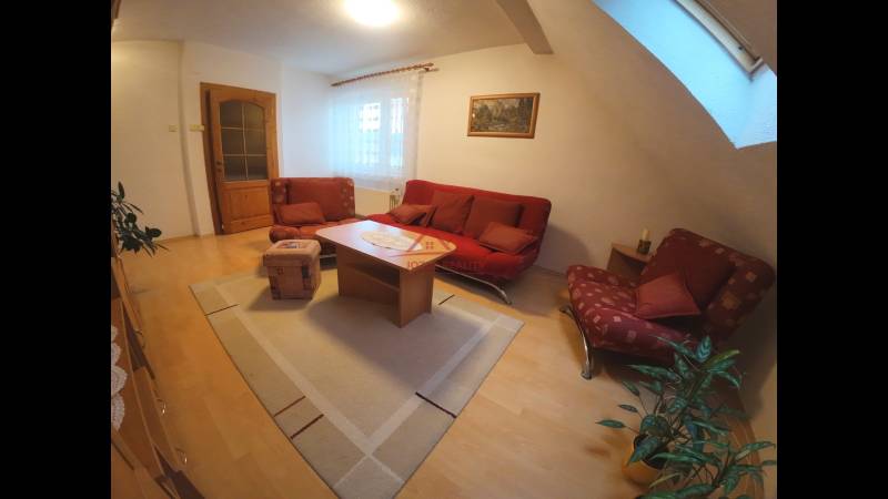 Living room in a family house with a red sofa and a wooden decor floor.