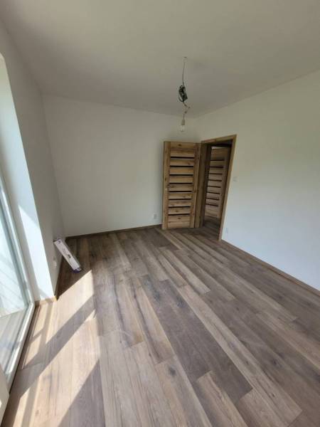 A room in a family house with a wooden decor floor and wooden doors.