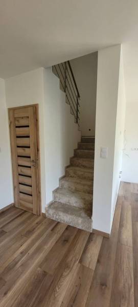 Interior of a family house with a wood-decorated floor and a staircase.