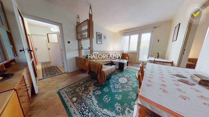 Living room with wood-patterned flooring, bright space in a 3-room apartment.