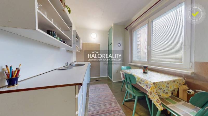 Kitchen in a 3-room apartment with a table and chairs, light decoration, practical arrangement.