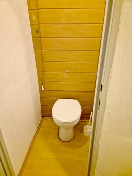 A toilet with wooden decor in a studio apartment.