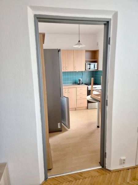 A kitchen with wooden decor and appliances in a studio apartment.