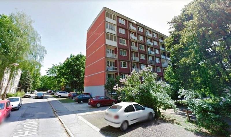 Apartment building on A. Hlinka Street in Piešťany, surrounded by greenery and parked cars.