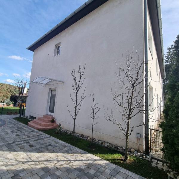 Exterior of the house with entrance and garden, suitable for a comfortable 3-room apartment.