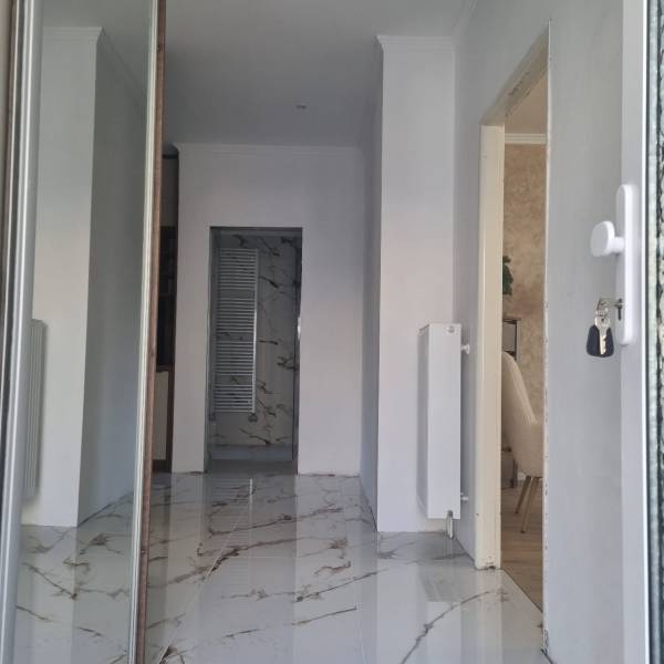 A hallway with marble flooring and radiators in a 3-room apartment, entrance to the room.